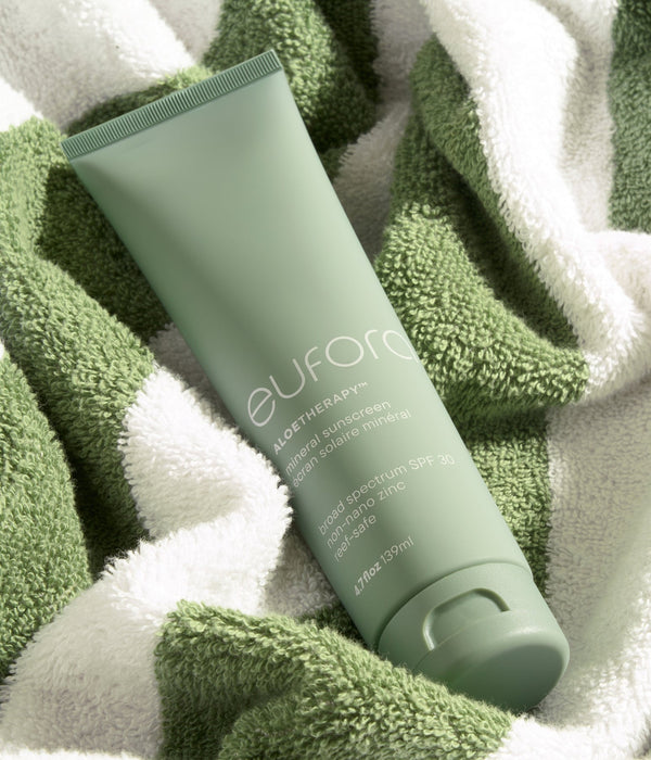 Eufora Aloetherapy SPF 30 Mineral Sunscreen tube resting on a green and white striped towel